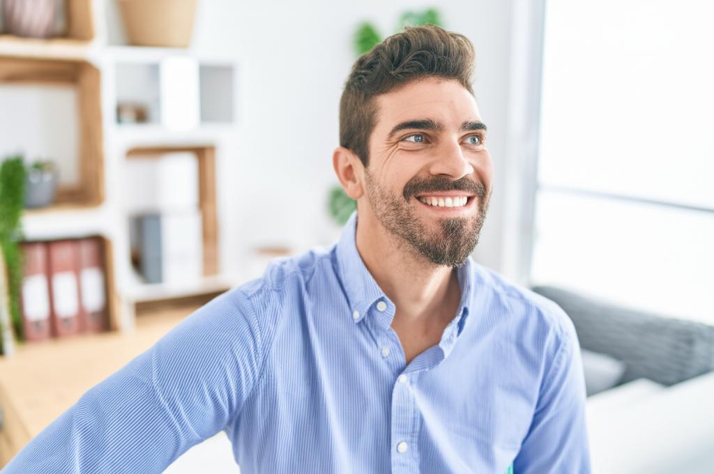 Smiling man looking confident and happy, perhaps in a comfortable setting